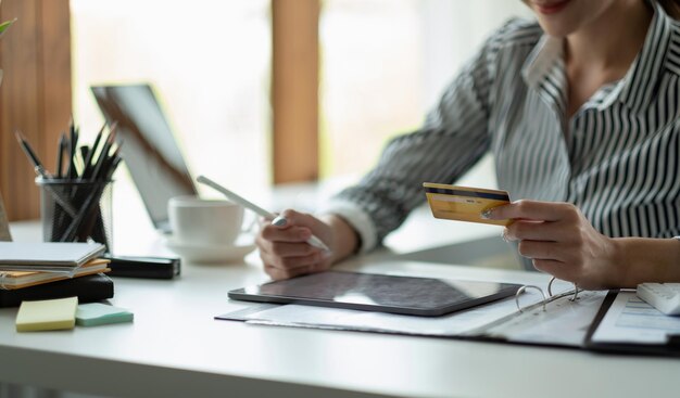 Technologie Asiatin Online-Shopping-Konzept Glücklich lächelnde Frau mit Tablet-PC-Computer und Kreditkarte zu Hause