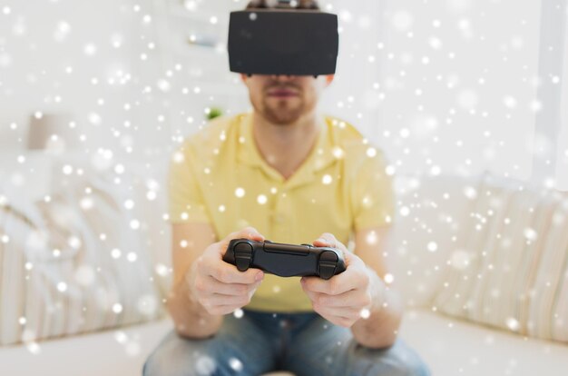 Technologie, Augmented Reality, Gaming, Unterhaltung und People-Konzept – Nahaufnahme eines glücklichen jungen Mannes mit virtuellem Headset oder 3D-Brille, der zu Hause über dem Schnee ein Videospiel mit einem Controller-Gamepad spielt