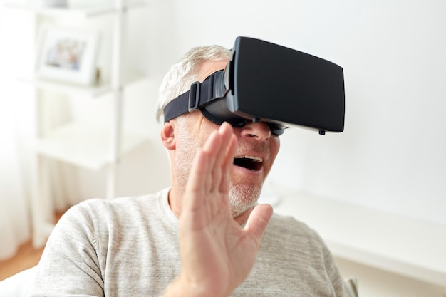 Technologie-, Augmented-Reality-, Gaming-, Unterhaltungs- und People-Konzept – älterer Mann mit virtuellem Headset oder 3D-Brille, der zu Hause Videospiele spielt