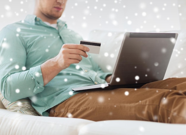 Foto technologie-, einkaufs-, bank-, haus- und personenkonzept - nahaufnahme eines mannes mit laptop-computer und kreditkarte zu hause
