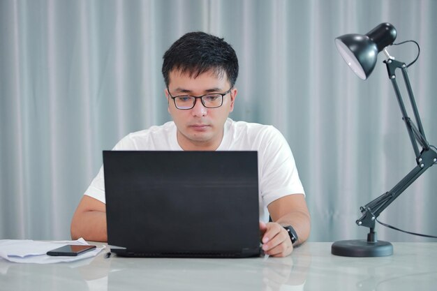 Technologie-Remote-Job und Lifestyle-Konzept glücklicher asiatischer Mann Mann mit Brille.