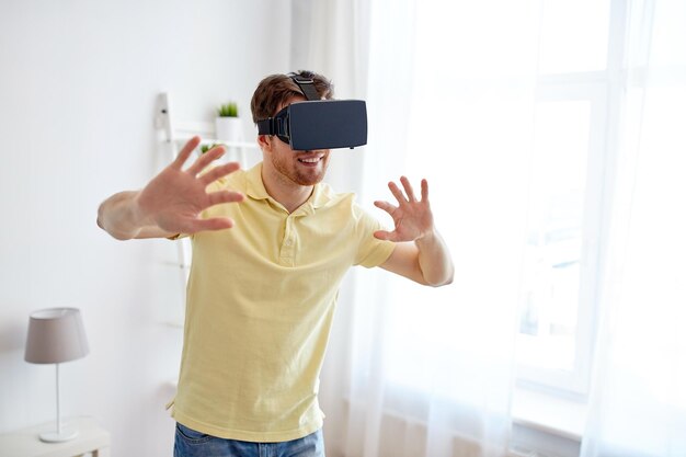 technologie-, spiel-, unterhaltungs- und menschenkonzept - glücklicher junger mann mit virtual-reality-headset oder 3d-brille, der videospiel spielt