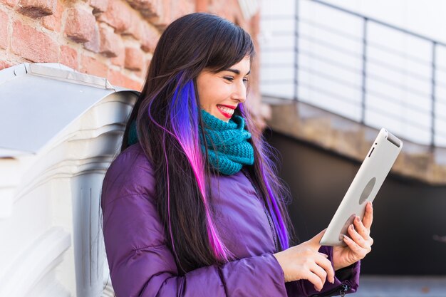 Technologie-, Stadt- und Personenkonzept - Studentische junge Frau, die ein ebook oder Tablet in einer Stadt liest