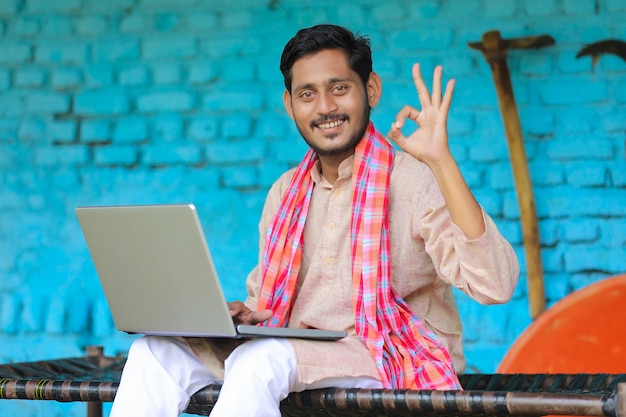 Technologiekonzept: Indischer Bauer mit Laptop zu Hause