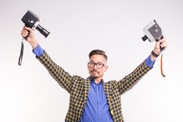 Technologien, Fotografieren und Personenkonzept - schöner junger Mann mit zwei lächelnden Retro-Kameras