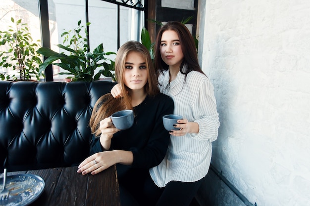 Technologien, Lifestyle, Essen, Menschen, Teenager und Kaffeekonzept - Zwei junge Frauen machen Selfie mit Smartphone im Stadtzentrum. Glückskonzept über Menschen, Tee trinken