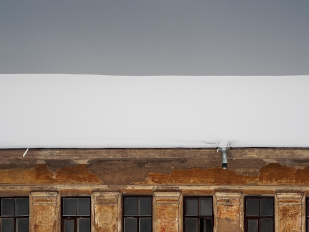 Foto el techo de la casa antigua está cubierto de nieve. un techo cubierto de nieve de una casa antigua.