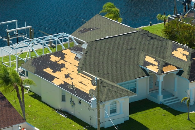 Techo de casa dañado con tejas faltantes después del huracán Ian en Florida Consecuencias del desastre natural