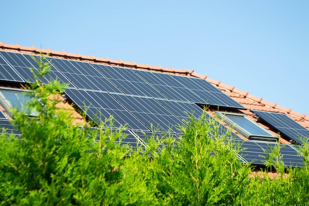 Techo de casa con módulos fotovoltaicos. Casa de campo histórica con paneles solares modernos en el techo y la pared