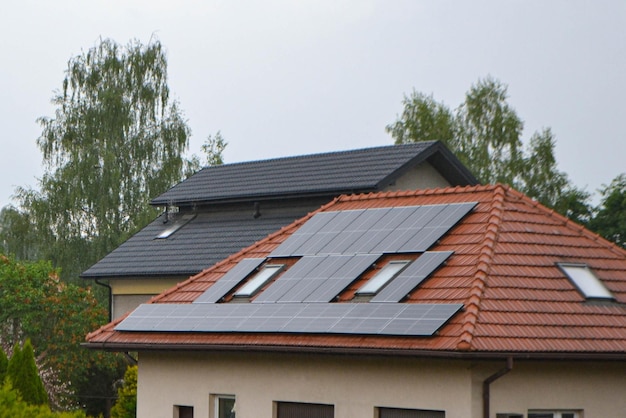 Techo de casa con módulos fotovoltaicos. Casa de campo histórica con paneles solares modernos en el techo y la pared