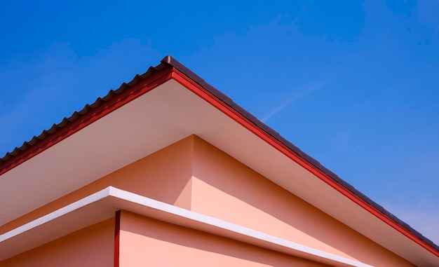 Techo de cobertizo de casa naranja en estilo moderno contra fondo de cielo azul claro en perspectiva vista lateral