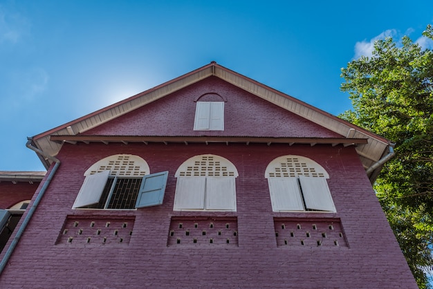 Techo a dos aguas, casa antigua con ventanas de madera.