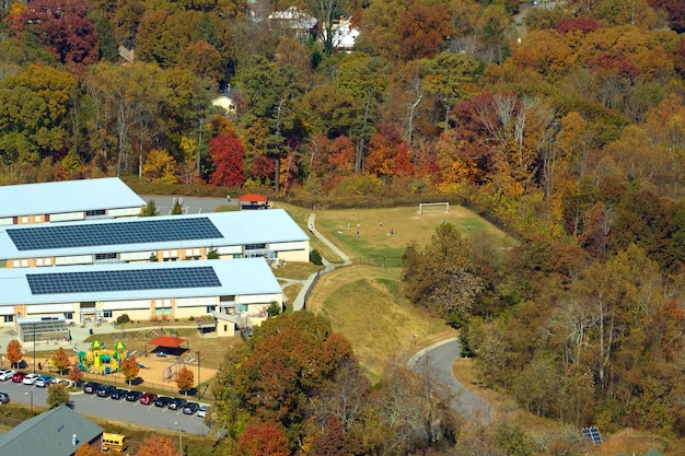 Techo del edificio de la escuela americana cubierto con paneles solares fotovoltaicos para la producción de energía eléctrica Concepto de energía renovable