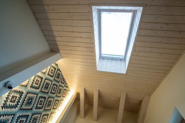 Foto techo de madera en una habitación abuhardillada contemporánea con ventana del ático de superficie de tablones decorativos.