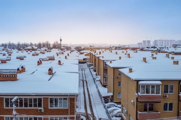 Techos de casas cubiertos de nieve en invierno. Panorama de la ciudad, vista superior.