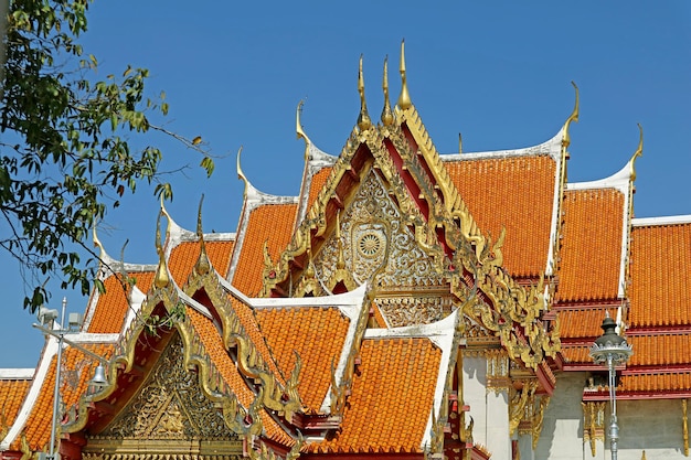 Techos a dos aguas de la Ordenación Hall con fantásticos frontones en Wat Benchamabophit Bangkok Thailand