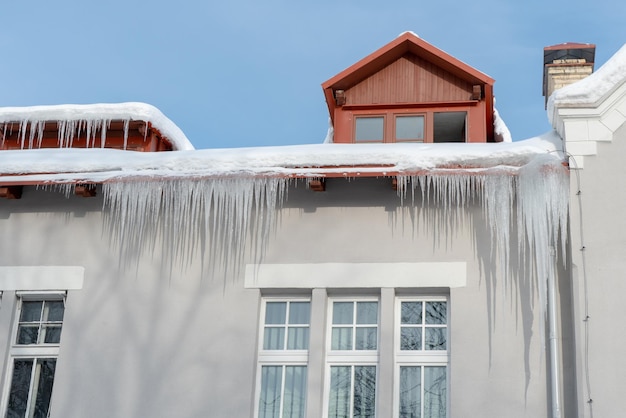 Los techos de los edificios se cubren de nieve y hielo tras una gran nevada Enormes carámbanos cuelgan de las fachadas de los edificios La caída de los carámbanos conlleva un peligro para la vida de las personas