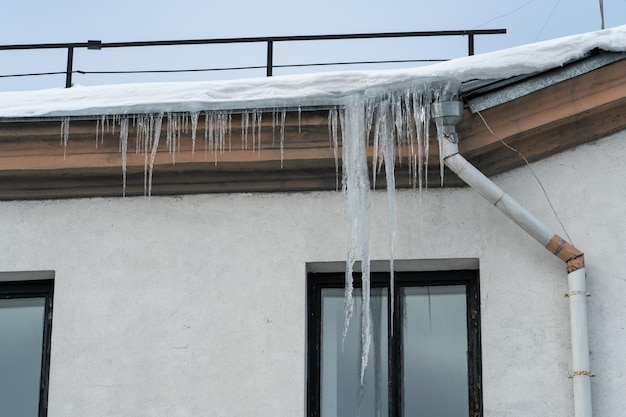 Los techos de los edificios se cubren de nieve y hielo tras una nevada Carámbanos cuelgan de las fachadas de los edificios La caída de carámbanos conlleva un peligro para la vida de las personas El desagüe congelado