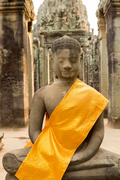 Tecidos amarelos ao redor de Buda no templo de Angkor Wat Camboja