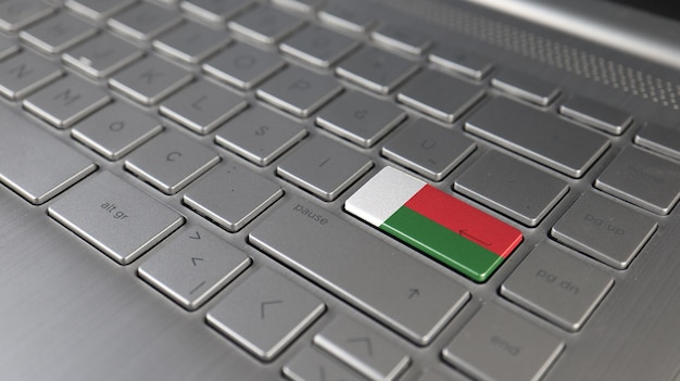 Foto el teclado con la bandera de madagascar en el botón de entrada representa el lenguaje de aprendizaje de ataque cibernético