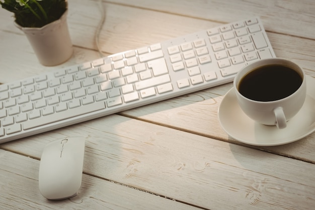 Teclado blanco y taza de café