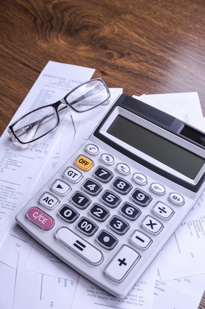 Teclado calculadora con cheques de la tienda de compras en un piso de madera