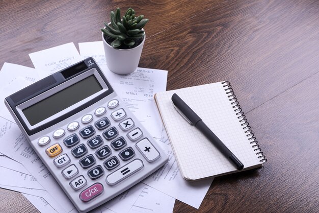 Teclado de la calculadora con cheques de la tienda de compras sobre un fondo de piso de madera. Vista superior. Copia espacio