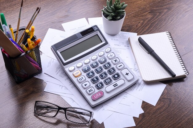 Teclado de la calculadora con cheques de la tienda de compras sobre un fondo de piso de madera. Vista superior. Copie el espacio.