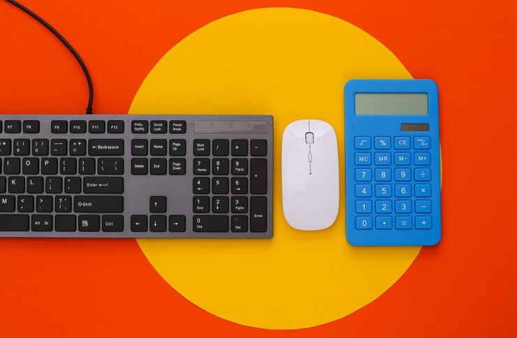 Foto teclado y calculadora de pc en naranja con círculo amarillo
