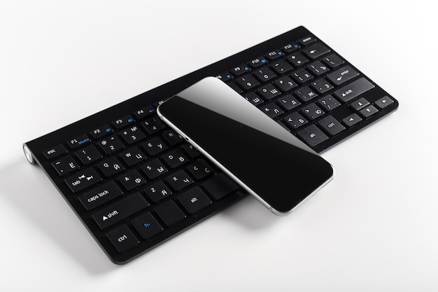 Teclado com celular em cima da mesa