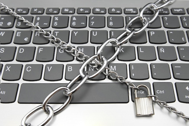 Un teclado de computadora con una cadena y un candado concepto de ciberseguridad