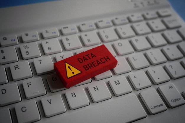 Teclado de computadora y cubo de madera rojo con texto DATA BREACH Tecnología de Internet y concepto de red