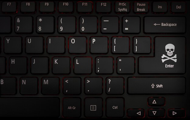 Teclado de computadora con icono pirata hacker