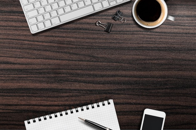 Teclado de computadora en el lugar de trabajo y taza aislado en el fondo