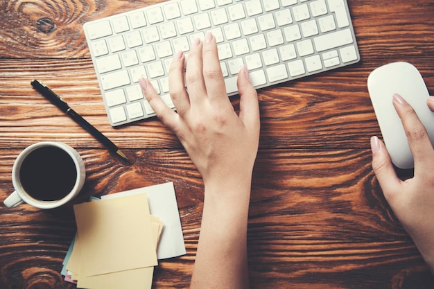 Teclado de computadora de mano de mujer en la mesa