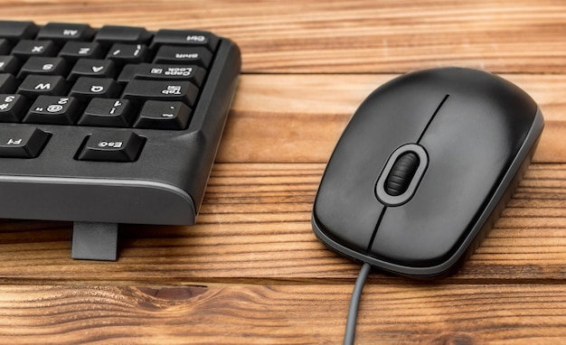 Foto teclado de computadora con ratón de computadora en una mesa de madera