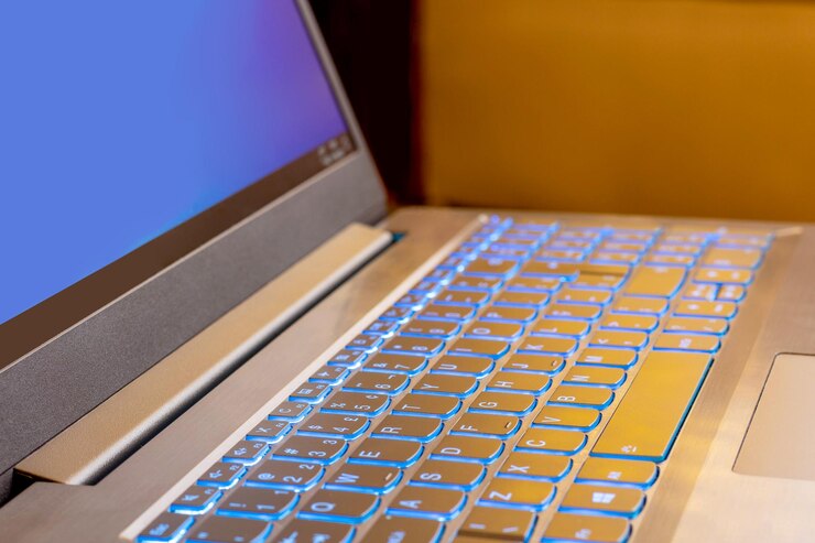 Foto teclado de computadora con teclas iluminadas y pantalla azul
