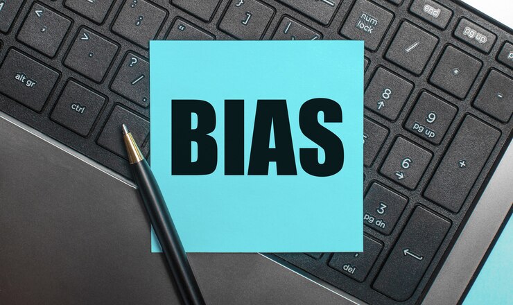 Foto el teclado de la computadora tiene un bolígrafo y una etiqueta azul con el texto bias. endecha plana.