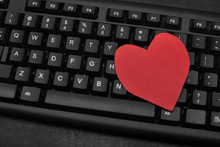 Foto teclado y corazón rojo. concepto de citas online. citas por internet. relación de texto.