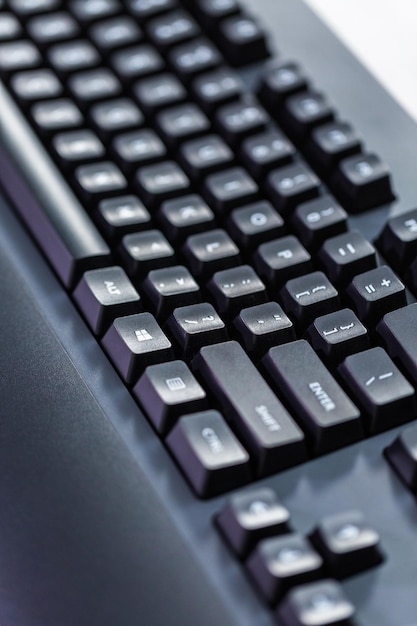 Teclado de computador preto moderno com teclas levantadas.