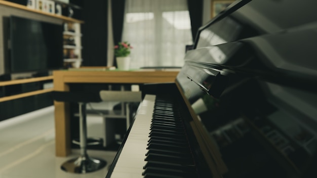 Teclado de piano com desfoque de fundo na sala de estar em casa com decoração de interiores moderna.