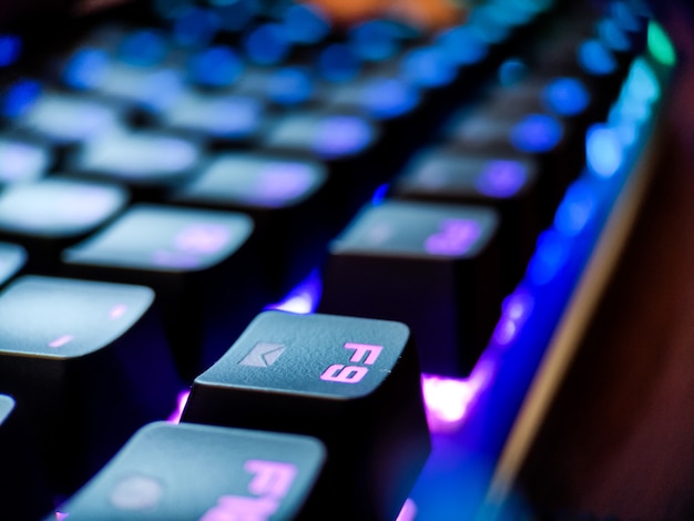 Teclado do jogador com macro de luz de fundo de néon desfocado close-up. Jogos online e fundo do conceito de realidade virtual. Foto de alta qualidade