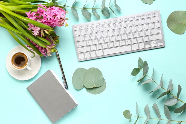 Teclado e café com flores na vista de cima da mesa