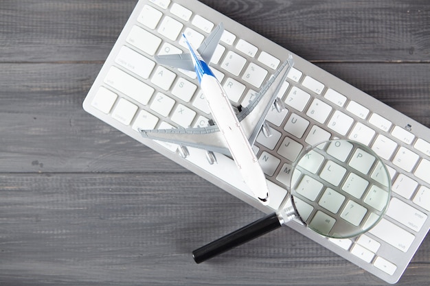 Teclado e lupa. conceito de pesquisa na mesa de madeira cinza