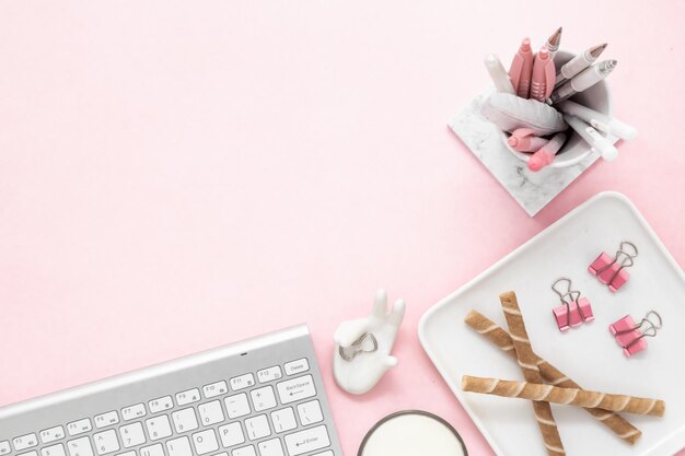 Foto un teclado de espacio de trabajo femenino de la computadora en un fondo rosa con espacio de copia