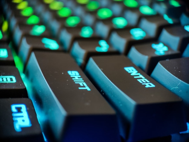 Teclado de jugador con macro retroiluminación de neón desenfocado de cerca. Juegos en línea y fondo del concepto de realidad virtual. Foto de alta calidad