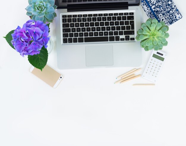 Teclado moderno para laptop e telefone na mesa branca