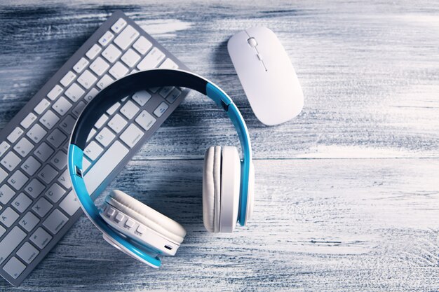 Teclado, mouse y auriculares en la mesa.