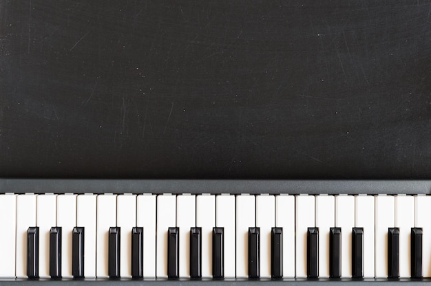 Teclado de música en el fondo de la pizarra para niños de escuela de música con espacio de copia