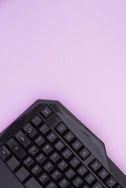 Teclado, sobre um fundo rosa, vista superior. Dispositivo de computador, vista superior. Lay plana de espaço de trabalho.